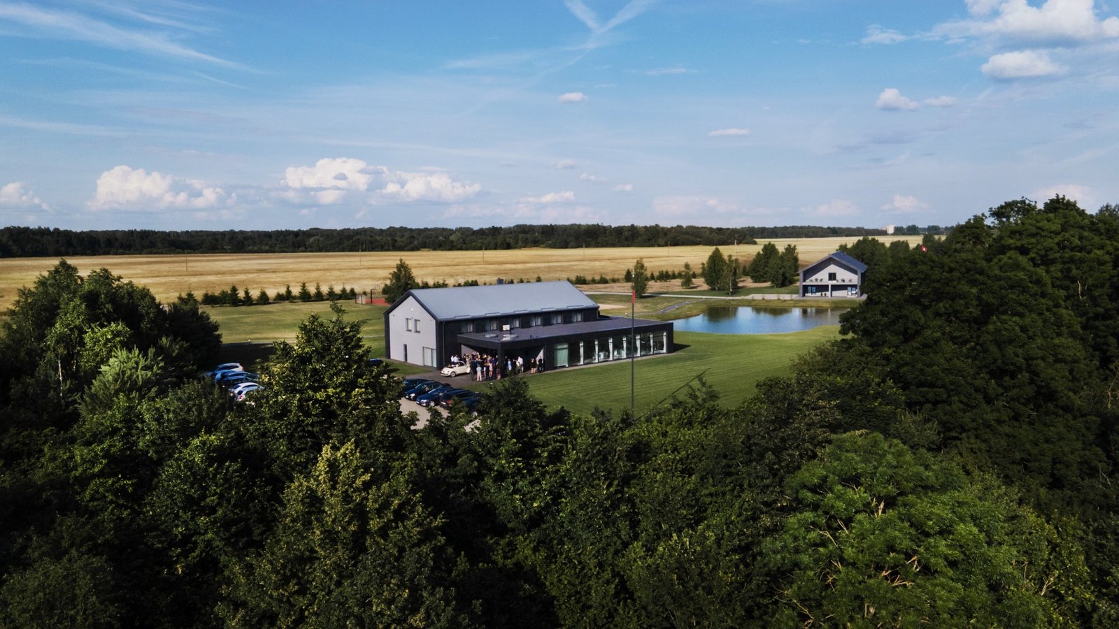 Sodyba Varnupė iš aukštai — pokylių salė ir tvenkinys laukų apsuptyje